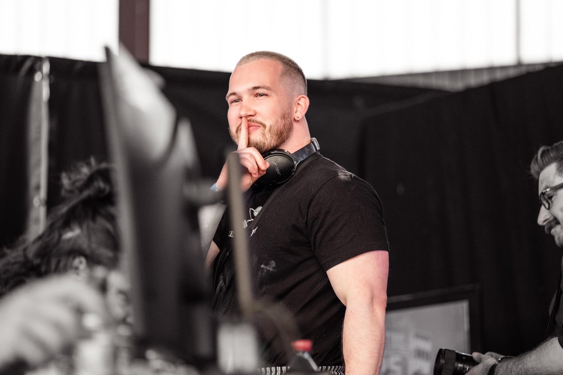 Leon, Coach bei Real Gym Shady Coaching, hält den Zeigefinger vor den Mund